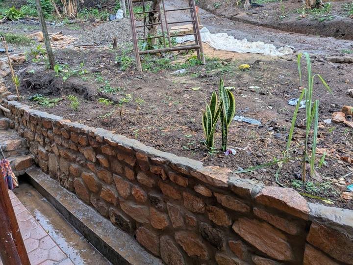 Un muro de contención de piedra y los nuevos canteros.